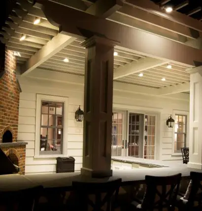 Cozy outdoor patio with down lights lighting creating an inviting ambiance at night.