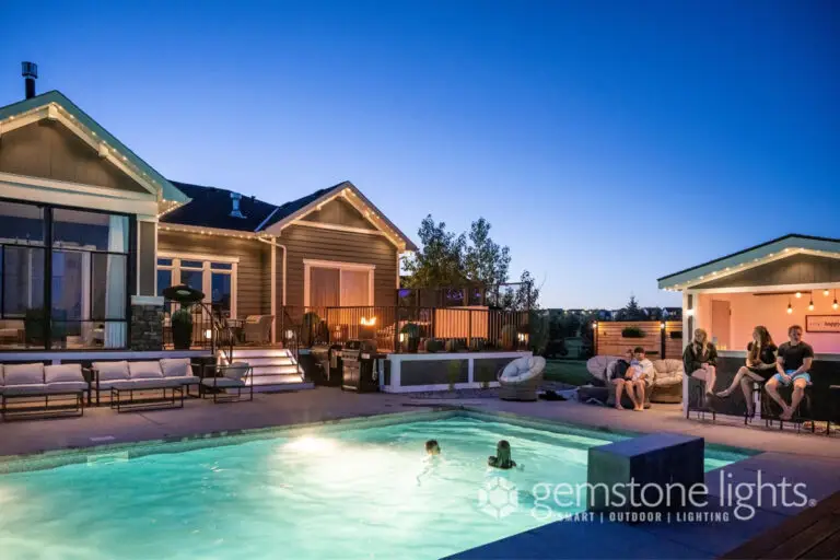 Soft white LED lighting illuminating a backyard patio and poolside bar at sunset
