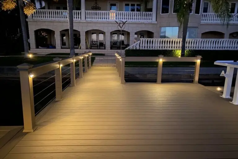 Well-lit dock with modern LED post lights leading to a luxury waterfront home in Emerald Coast, Florida