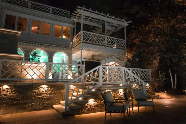 Elevated deck and steps with architectural lighting and white railings at night