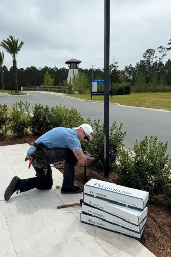 Technician installing outdoor lighting fixture at commercial entrance in Panama City