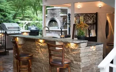 FX Luminaire lighting installed in stone outdoor kitchen counter with stools and grill area