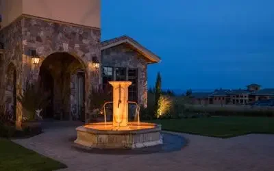 FX Luminaire Underwater Light Enhancing Entry Fountain FX Luminaire underwater lighting illuminating a courtyard fountain in front of a stone home
