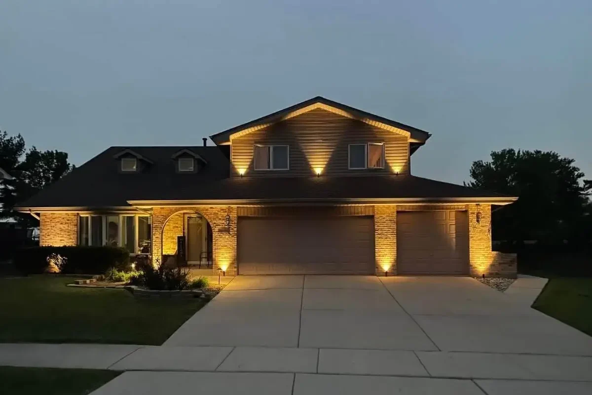 Outdoor lighting gallery view of a tiered retaining wall and landscape uplighting installation