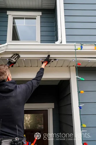 Close-up view of permanent LED soffit lighting being adjusted