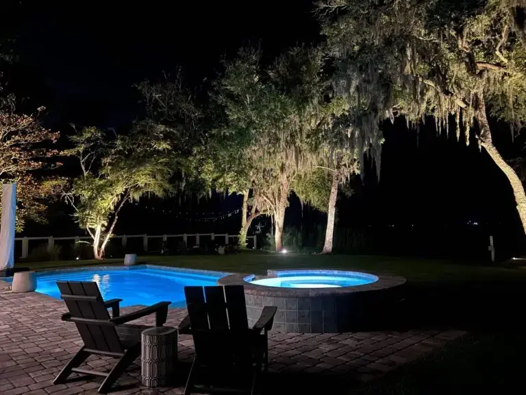 Panama City backyard with illuminated pool, spa, and moss-draped trees by Emerald Coast Illumination