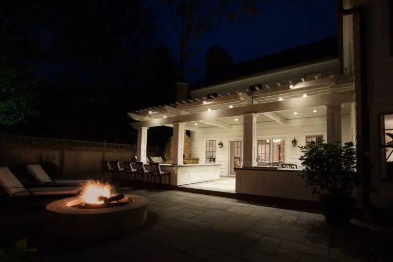 Covered patio with overhead lighting and a glowing fire feature for cozy outdoor evenings